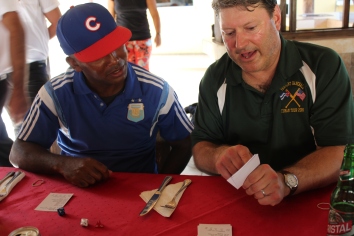 Coach Tom teaches the Cuban coach how to play dice baseball.