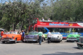 A row of colorful classic cars line the street in the Capital District of Havana.